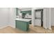 Kitchen area features green cabinetry, a white island, stainless appliances, and laundry closet at 108 Colville Rd # 21B, Charlotte, NC 28207
