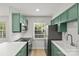 Modern kitchen with green cabinets, stainless steel appliances, and ample natural light at 108 Colville Rd # 21B, Charlotte, NC 28207