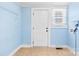 Blue utility room with white door, wire rack, and a window at 108 Franklin Ave, Kannapolis, NC 28081