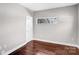 Minimalist bedroom with hardwood floors, white walls, and a window providing natural light at 111 W Poindexter Dr, Charlotte, NC 28203
