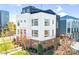 Striking modern townhome with white exterior, complemented by well-kept landscaping and trees at 111 W Poindexter Dr, Charlotte, NC 28203