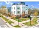 Modern townhome with white siding, brick accents, manicured lawn, and vibrant orange door at 111 W Poindexter Dr, Charlotte, NC 28203