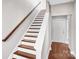 Interior staircase with white risers, stained treads, and a stained handrail at 111 W Poindexter Dr, Charlotte, NC 28203