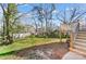Backyard view showing a large grassy area, mature trees, wooden playset and elevated deck at 124 Washington St, York, SC 29745