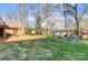 Backyard view showing a large grassy area, mature trees, wooden playset and elevated deck at 124 Washington St, York, SC 29745