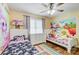 Bright bedroom with two beds, white dresser, ceiling fan, and colorful wall art at 124 Washington St, York, SC 29745