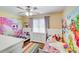 Bright bedroom with two beds, white dresser, ceiling fan, and colorful wall art at 124 Washington St, York, SC 29745