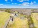 An aerial view of a vast property featuring multiple buildings and a paddock area at 12613 Oak Grove Rd, Stanfield, NC 28163