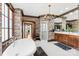 Spacious bathroom features a soaking tub, chandelier, glass enclosed shower, and a wood vanity at 12613 Oak Grove Rd, Stanfield, NC 28163