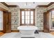 Luxurious bathroom with freestanding tub, unique wallpaper, wood trim and access doors to and closets at 12613 Oak Grove Rd, Stanfield, NC 28163