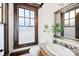 Cozy powder room featuring a granite-topped sink, decorative mirror, and frosted window at 12613 Oak Grove Rd, Stanfield, NC 28163