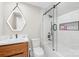 Modern bathroom featuring a glass shower door, a unique vanity mirror, and wood-tone cabinets at 12613 Oak Grove Rd, Stanfield, NC 28163