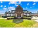 A grand exterior view of the home showcasing its brick and white siding, gabled roof, and lush landscaping at 12613 Oak Grove Rd, Stanfield, NC 28163