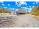 A large greenhouse stands ready for year-round gardening, surrounded by gravel and open space at 12613 Oak Grove Rd, Stanfield, NC 28163