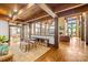 Spacious living room featuring hardwood floors, wooden ceiling beams, stone fireplace, and large windows at 12613 Oak Grove Rd, Stanfield, NC 28163