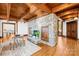 Living room boasts a stone fireplace, wooden ceiling beams, hardwood floors, and a neutral color palette at 12613 Oak Grove Rd, Stanfield, NC 28163