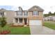 Charming two-story home with a brick facade, attached garage, covered porch, and manicured front lawn at 1325 Secrest Commons Dr, Monroe, NC 28112