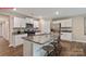 Well-lit kitchen features stainless steel appliances, granite countertops, and a spacious island with seating at 1344 Secrest Commons Ct, Monroe, NC 28112