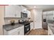 Modern kitchen with stainless steel appliances, granite countertops, and sleek white cabinetry at 1344 Secrest Commons Ct, Monroe, NC 28112