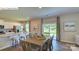 Open-concept dining area with a wooden dining table, stool seating at kitchen island, and sliding door access to patio at 1353 Secrest Commons Dr, Monroe, NC 28112