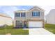 Charming two-story home featuring stone accents, neutral siding, dark shutters, manicured lawn, and a two-car garage at 1353 Secrest Commons Dr, Monroe, NC 28112