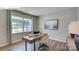 Bright home office with wood floors, a contemporary desk, neutral walls, and a large window offering a green view at 1353 Secrest Commons Dr, Monroe, NC 28112