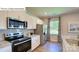 Close-up of a modern kitchen with stainless steel appliances, granite countertops, and white cabinets at 1353 Secrest Commons Dr, Monroe, NC 28112