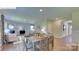 Open living space with wooden dining table, gray sofas, white walls, a fireplace, and a large window at 1353 Secrest Commons Dr, Monroe, NC 28112