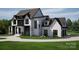 Beautiful two-story home with a manicured lawn and a circular driveway leading to a two car garage at 13820 E Rocky River Rd, Davidson, NC 28036