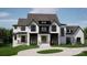 Stunning two-story home featuring a modern design, black window frames, and landscaped front yard at 13820 E Rocky River Rd, Davidson, NC 28036