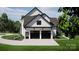 Side view of a two-car garage showcasing its modern black doors, white siding, and manicured lawn at 13820 E Rocky River Rd, Davidson, NC 28036
