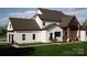 Expansive house showcasing timber beamed patio and rear entrance with ample parking and green backyard at 13820 E Rocky River Rd, Davidson, NC 28036