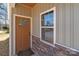 Inviting entryway featuring a stylish wood door, stone accents and a bright window for natural light at 140 Swimmers Ln, Salisbury, NC 28146