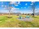 Picturesque backyard featuring a fire pit with chairs, a sprawling lawn, and mature trees at 1429 Scotts Creek Rd, Statesville, NC 28625