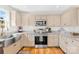 Well-equipped kitchen featuring stainless steel appliances, farmhouse sink, granite countertops, and ample cabinet space at 1429 Scotts Creek Rd, Statesville, NC 28625