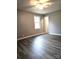 This bedroom features modern gray walls, light gray flooring, a ceiling fan, and a bright window at 1607 W Nc 27 Hwy, Lincolnton, NC 28092