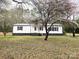 Inviting home exterior featuring a manicured lawn and mature tree, enhancing the property's curb appeal at 1607 W Nc 27 Hwy, Lincolnton, NC 28092