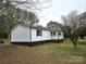 A distant view of the home, surrounded by a forest and open field at 1607 W Nc 27 Hwy, Lincolnton, NC 28092