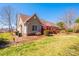 Landscaped backyard with a green lawn, mature trees, and a charming outdoor seating area at 1636 Samaria Ln, Conover, NC 28613