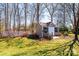 Backyard shed with a charming white picket fence, surrounded by mature trees and a green lawn at 1636 Samaria Ln, Conover, NC 28613