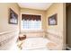 Relaxing main bathroom boasts a soaking tub, travertine tile and decorative accents at 1636 Samaria Ln, Conover, NC 28613