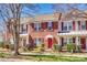 Charming townhouse with brick facade, red door, and well-maintained landscaping for curb appeal at 19009 Coachmans Trce, Cornelius, NC 28031
