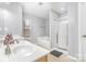 Bright bathroom with double sinks, a soaking tub, and a glass-enclosed shower, providing a spa-like experience at 2157 Tommy Ln, Matthews, NC 28105