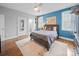 A bedroom with hardwood floors, a blue accent wall, and an ensuite bathroom at 3024 Beaver Dam Dr, Monroe, NC 28110