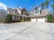 Beautiful brick and stone home featuring a spacious driveway, front porch and a three car garage at 3024 Beaver Dam Dr, Monroe, NC 28110