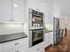 Modern kitchen featuring stainless steel double oven and range, complemented by sleek black countertops and white cabinetry at 3024 Beaver Dam Dr, Monroe, NC 28110