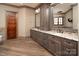 Elegant bathroom featuring double sinks, granite countertops, custom cabinetry, and wood-look tile flooring at 3200 Beaty Rd, Gastonia, NC 28056