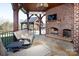 Cozy outdoor living space with a brick fireplace and comfortable seating overlooking a landscaped backyard at 3200 Beaty Rd, Gastonia, NC 28056