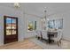 Elegant dining room with a chandelier, wood floors, large windows, and seating for six at 3324 Flamingo Ave, Charlotte, NC 28205