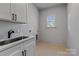 Clean, bright laundry room with modern cabinetry, a sink, and black hardware at 3324 Flamingo Ave, Charlotte, NC 28205